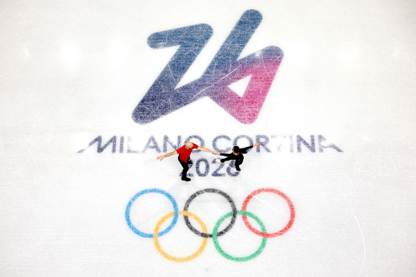 coppia di pattinatori vista dall'alto al centro della pista del ghiaccio con il logo delle olimpiadi invernali MILANO CORTINA 2026